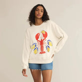Woman wearing a white sweatshirt with a colorful lobster design